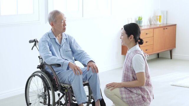 車椅子に乗った高齢者のサポートをする介護士