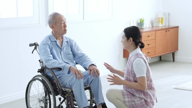 車椅子に乗った高齢者のサポートをする介護士