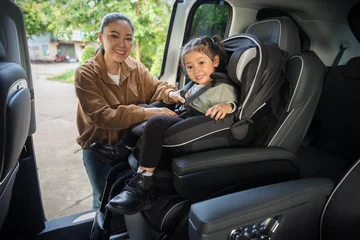mother is fastening safety belt to preschool child girl in car seat, safety baby chair travelling © geargodz