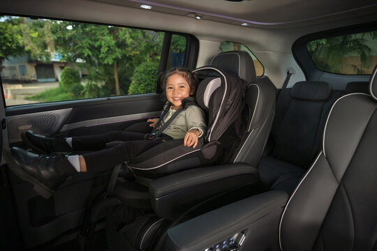 happy preschool child girl sitting in car seat, safety baby chair travelling