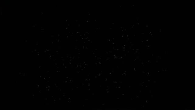 Dark gray debris particles and rocky dust exploding outward for cosmic asteroid collision concept vfx motion graphics design video overlay effect on black background