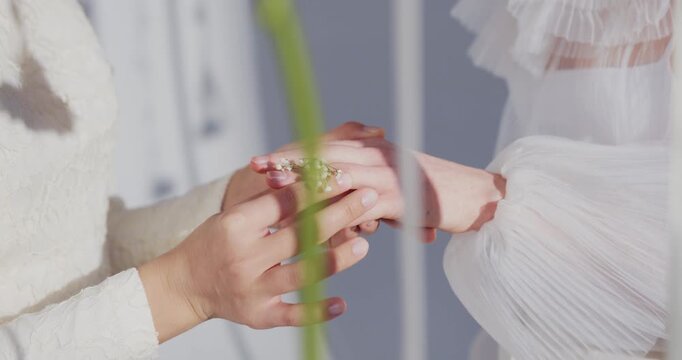 sliding on finger, marriage ritual, bride white dress, groom suit sleeve, delicate fingers, gentle placement, ring on ring finger,