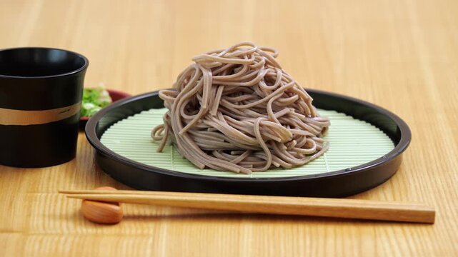 Chilled zaru soba noodles on a dinner table with sake, panning shot from left to right.