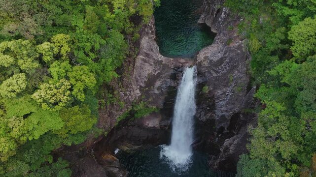 Flying over waterfalls and natural rock pools in forested canyon on Yakushima, Japan