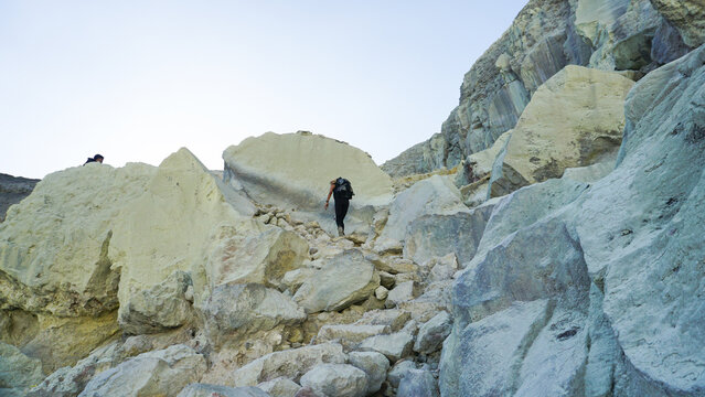 Woman Hiking Through Rocky Terrain at Ijen Crater, Banyuwangi Indonesia.