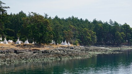 teepees in a campground close to the water © CP Studios