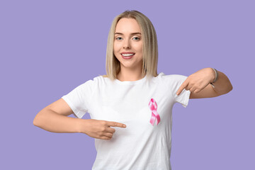 Fototapeta premium Young woman with pink ribbon on lilac background. Breast cancer awareness concept