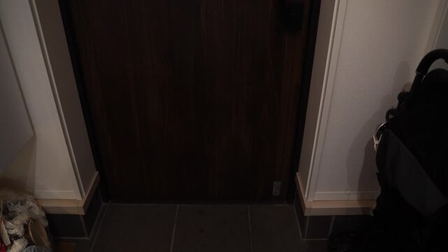 玄関ドアを開けて外へ出るビジネスマン