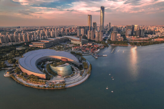 Aerial view of Jinji Lake with the Suzhou International Expo Center and modern skyscrapers in the background at sunset in Suzhou, Jiangsu, China.