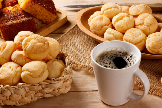 Brazilian breakfast with fresh black coffee and homemade cheese bread served in rustic baskets and platters, accompanied by corn cake.