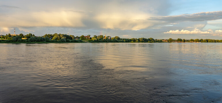 Wide river reflects sky's soft golden glow