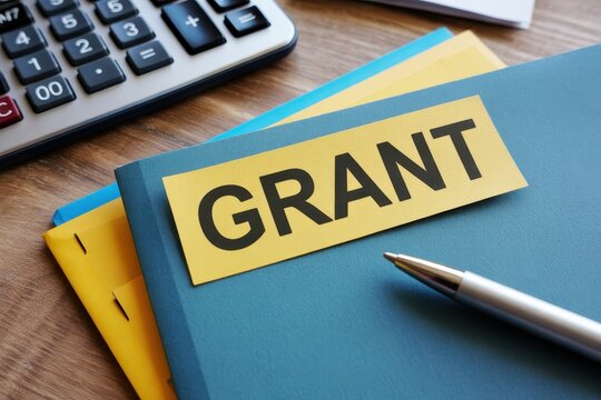 Grant proposal documents with calculator and pen on wooden desk