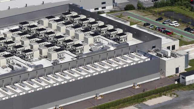High angle view showcasing the expansive rooftop of a modern data center, featuring rows of industrial cooling units and ventilation systems essential for maintaining server infrastructure