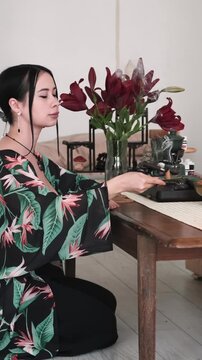 Vertical video. Aroma meditation. Spiritual practice. Woman burning candle on table for mental calming ritual aesthetic atmosphere.
