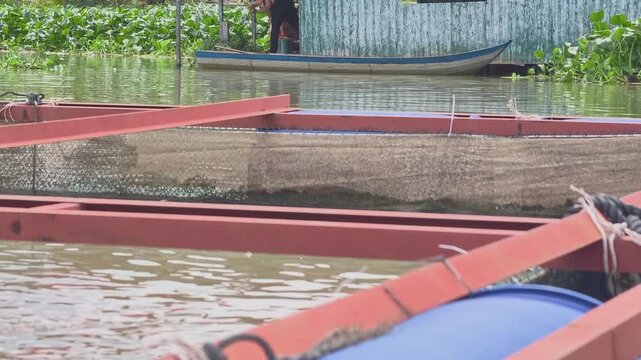 A local man fishing on a floating fish cage in the Mekong Delta, Vietnam