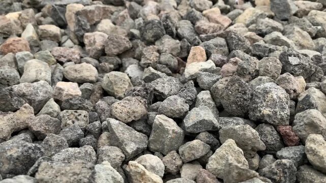 Close-up footage of crushed stones used as aggregate for construction, roadwork, drainage systems, and concrete production.