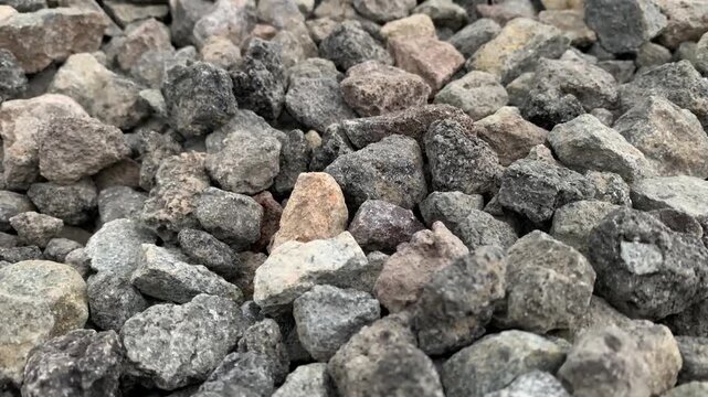 Close-up footage of crushed stones used as aggregate for construction, roadwork, drainage systems, and concrete production.