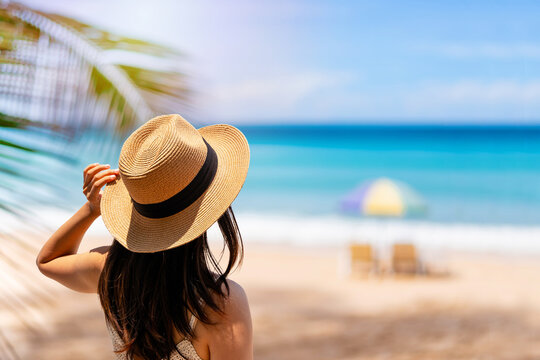 Young woman traveler relaxing and enjoying at beautiful tropical white sand beach, Summer vacation and Travel concept