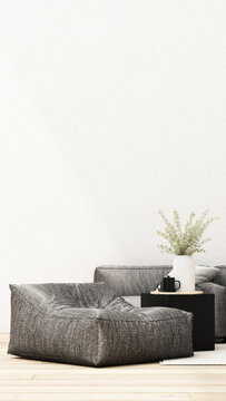 Minimalist grey living room with an oversized bean bag chair, charcoal sofa, black side table and eucalyptus arrangement.