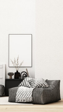 Contemporary monochrome lounge with a charcoal bean bag chair, patterned cushions and blanket, black cabinet and blank framed poster.