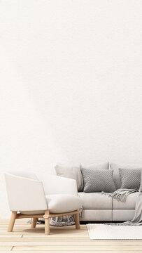 Soft neutral Scandinavian living room with a white wooden armchair, light grey sofa, textured cushions and abundant copy space.