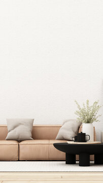 Warm beige minimalist living room with a low sofa, soft cushions, black coffee table and eucalyptus vase on a white rug.