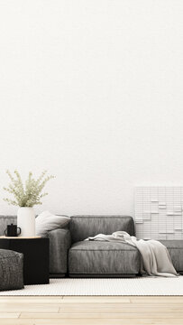 Modern neutral living room with a charcoal grey sectional sofa, black side table, eucalyptus vase, white rug and generous copy space.