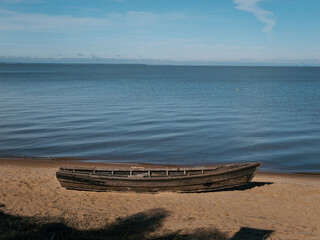 Obraz premium Weathered wooden boat sits on quiet sand