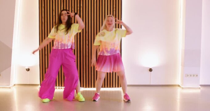 Clown dance. Rehearsal activity. Smiling female comedian in pink yellow color outfit performing dynamic fun show festive movement.