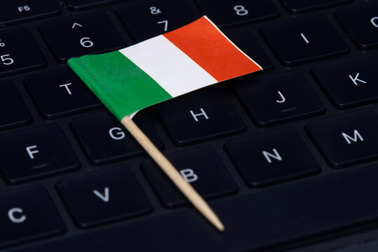 Italian flag on computer keyboard symbolizing digital economy, IT regulations, online work and high-tech job market in Italy.