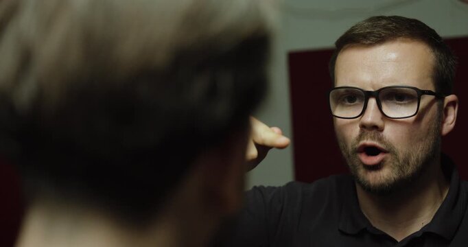 Manager speaking sternly to an employee during a tense workplace conversation about performance, mistakes, or expectations.