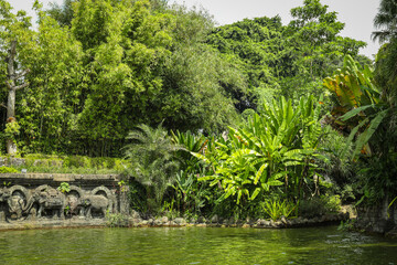 Fototapeta premium Green plants and trees surround a calm water area in Bali