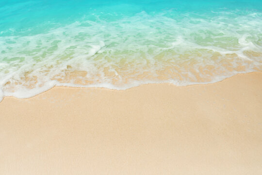 turquoise wave covering sandy beach, resort vacation concept as background