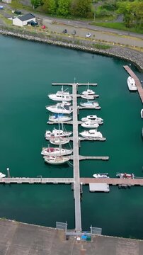 Clockwise vertical social ratio aerial video of Glenarm Harbour, on the Causeway Coastal Route in County Antrim, Northern Ireland in the UK on a sunny day. Produced in 3840x2160 and with Rec709 color.