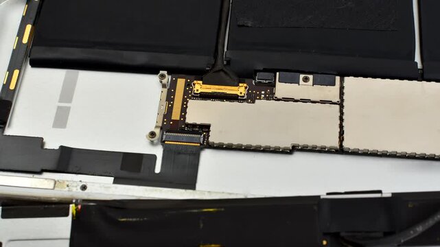 Close-up of tablet maintenance, showcasing technical care and precision in the repair process. Tablet repair close-up, showcasing tools and necessary care for an efficient maintenance process.