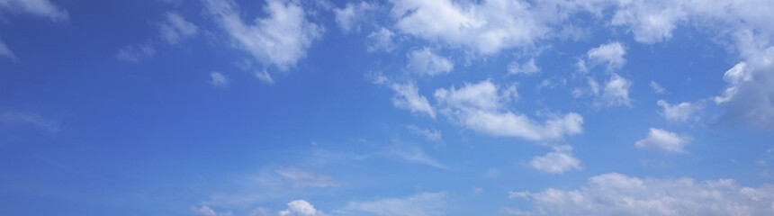 Obraz premium Clear blue sky background with subtle soft white clouds 