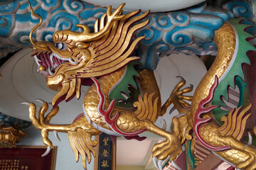 Obraz premium Intricate golden dragon sculpture with vibrant colors, symbolizing power and good fortune