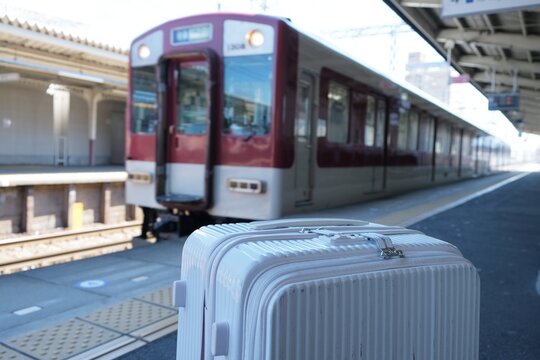 駅のホームに来た電車とスーツケース 旅
