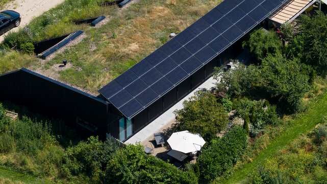 Aerial view of 't Eemgoed in Oosterwold, a modern house featuring a green roof and solar panels surrounded by lush vegetation in Almere, Flevoland, Netherlands.