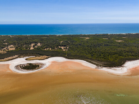 Aerial view of Lake Preston showing the salt crust shoreline, surrounding native vegetation, and the Indian Ocean in the background in Preston Beach, Western Australia, Australia.