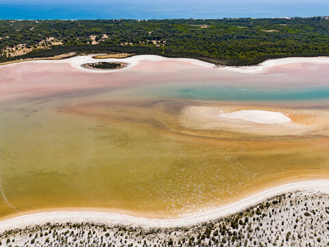 Aerial view of Lake Preston showing vibrant saline water patterns, sandy banks, and coastal scrubland, Preston Beach, Western Australia, Australia.
