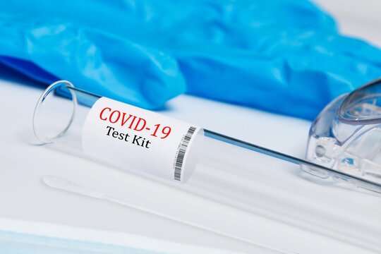ovid-19 PCR test kit vial with nasopharyngeal swab protective goggles and blue nitrile gloves for laboratory medical advertising and healthcare websites.