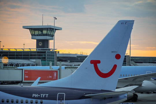 TUI airplane tail standing at Schiphol airport at dusk