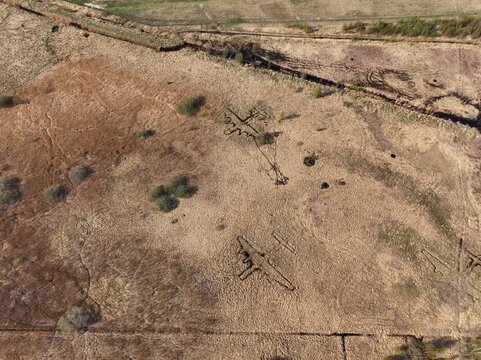 Aerial view of World War II decoy aircraft trenches shaped like plane outlines in a field near Liepaja Airport, Liepaja, Latvia.