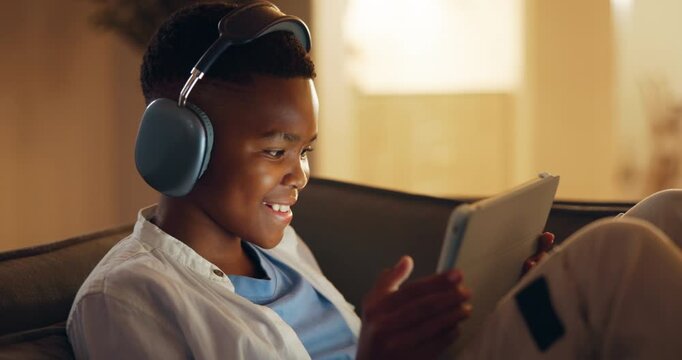 Tablet, fist pump and happy child in home with headphones, score points and online entertainment. Tech, audio and African boy in living room for gaming success, yes or victory achievement at night