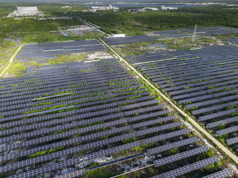 Aerial view of San Ignacio solar photovoltaic power plant with rows of solar panels installed in a rural landscape near Progreso, Yucatan, Mexico.
