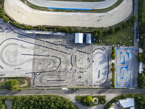 Aerial view of Autodromo Yucatan featuring an asphalt go-kart track with tire barriers, surrounding greenery, and an adjacent road in Progreso, Yucatan, Mexico.