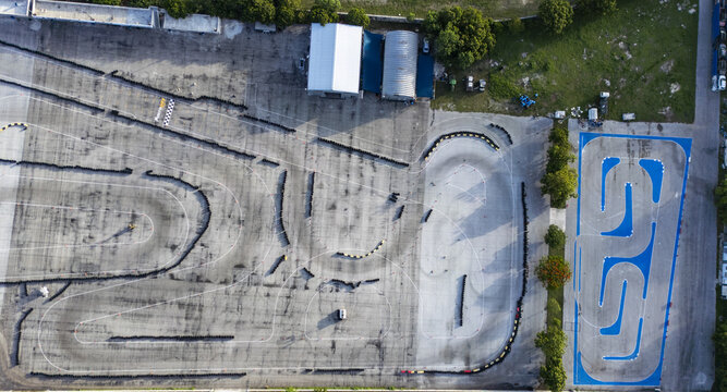 Aerial view of the Autodromo Yucatan go-kart track with asphalt racing lines, tire barriers, and a blue-painted practice circuit in Progreso, Yucatan, Mexico.
