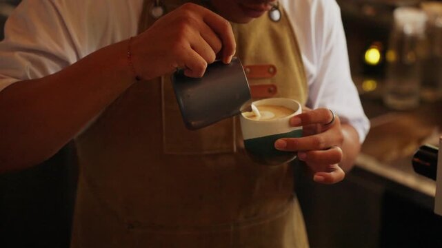 Professional barista creating beautiful coffee latte art