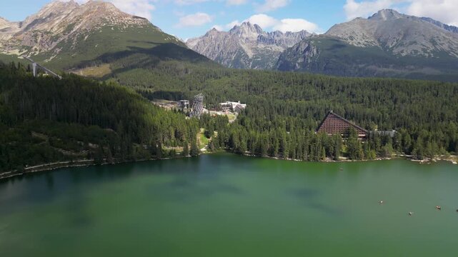 Drone Shot of &Scaron;trbsk&eacute; Pleso Lake with Alpine Buildings, Forests and High Tatras Peaks